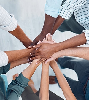 Diverse group of people with hands all in together as a team.